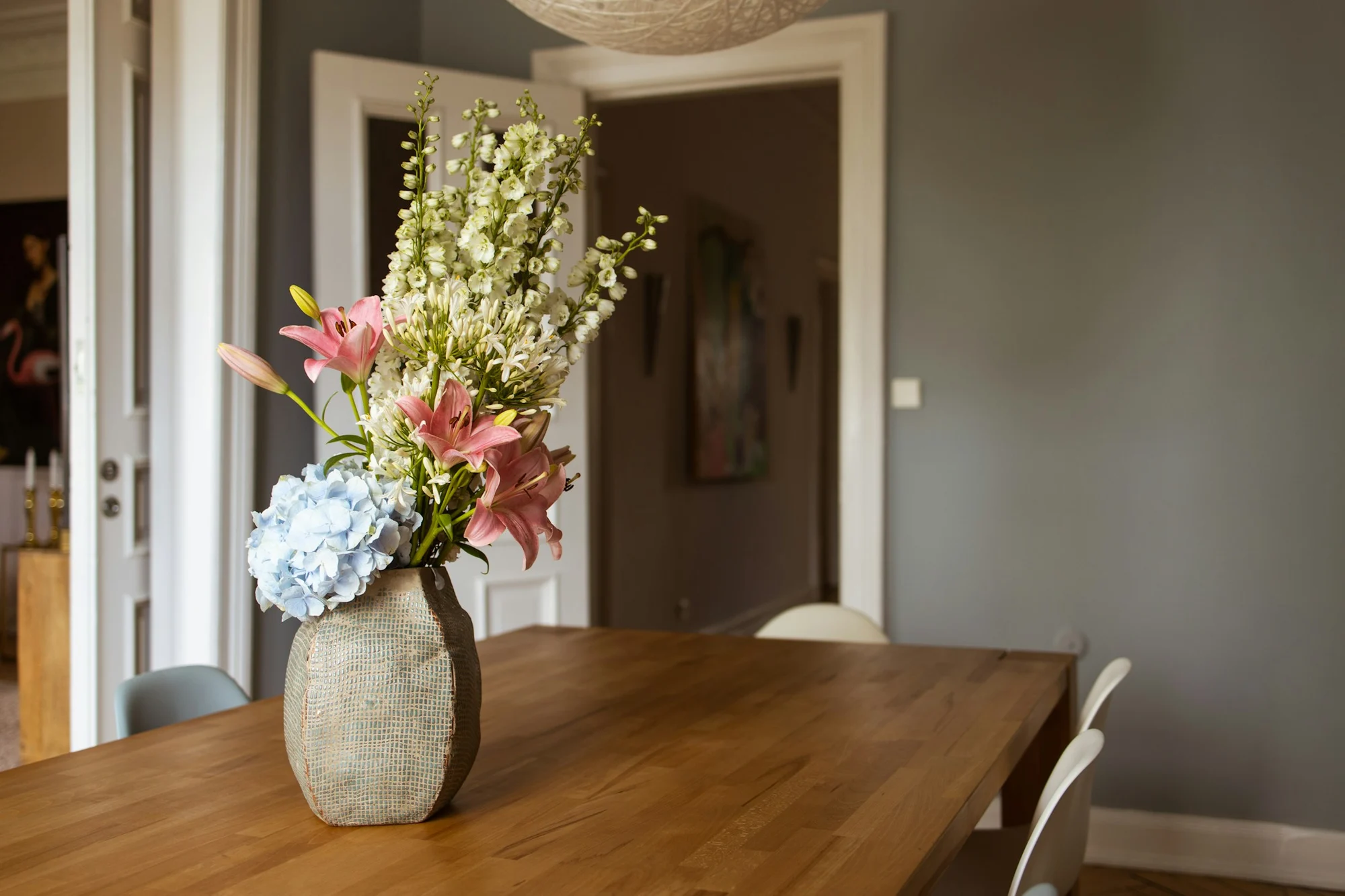Ein massiver Holztisch mit einer Vase in einem ruhigen Esszimmer
